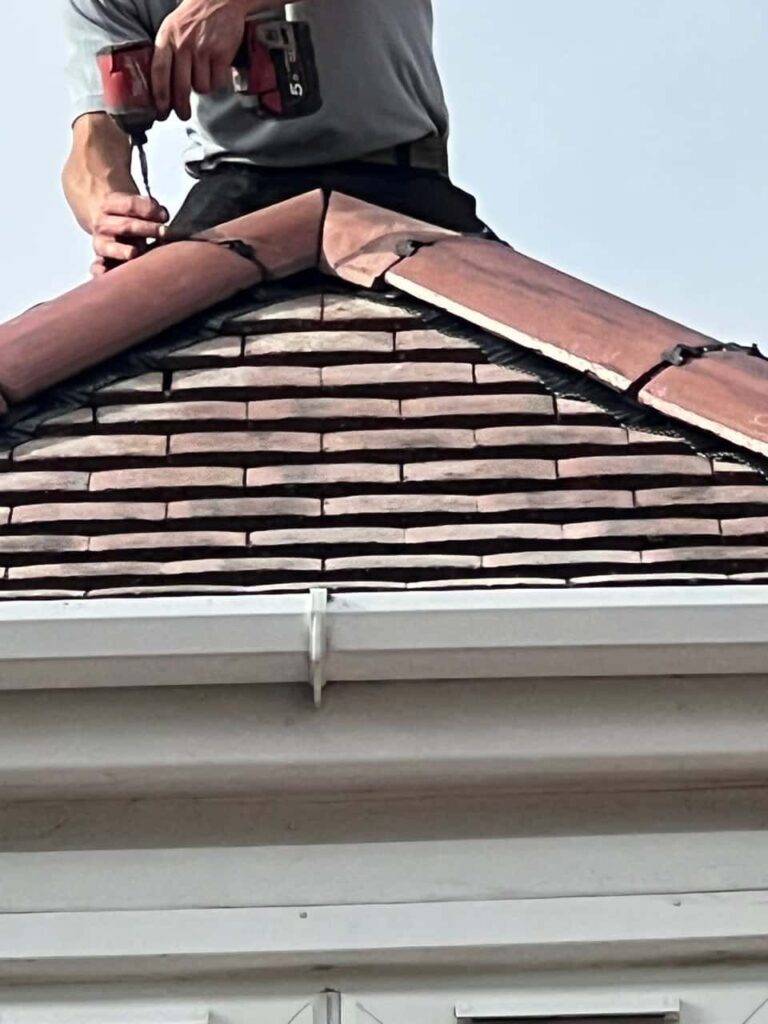 This is a photo of one of the operatives of Gainsborough Roofing Repairs installing new ridge tiles